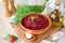 Beetroot saute with onions and tomatoes garlic and olive oil in a brown ceramic bowl on a olive wood cutting board