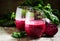 Beetroot smoothie in a large glass, fresh beets with tops, old w