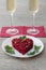 Beetroot and vegetables salad made in heart shape served with herbs on plate with two glasses of champagne