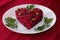 Beetroot and vegetables salad made in hearth shape served with herbs on plate