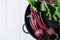 Beets with green tops in round metal pan on white wooden background, fresh red beetroot on backdrop kitchen table top view