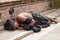 Beggar Sadhu, holy man asleep on the sidewalk a street in Kathmandu, Nepal