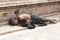 Beggar Sadhu, holy man asleep on the sidewalk a street in Kathmandu, Nepal