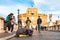 Beggar woman asking alms on her knees on Ponte Sant`Angelo, Bridge of Hadrian full of walking people with Castel Sant`Angelo,