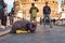 Beggar woman asking alms on her knees on Ponte Sant `Angelo, Bridge of Hadrian full of walking people with Castel Sant `Angelo,