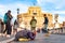 Beggar woman asking alms on her knees on Ponte Sant `Angelo, Bridge of Hadrian full of walking people with Castel Sant `Angelo,