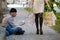 Beggars and wealthy woman with shopping bags