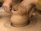 Beginner and teacher in process of making clay bowl on pottery w