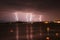 Beginning of a storm in a sea with lightnings in purple sky.