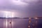 Beginning of a storm in a sea with lightnings in purple sky.