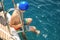 At the beginning of summer traveling on a yacht the boy preparing for swimming in the sea off the coast of the island of Poros in