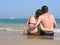 Behind couple sit on beach