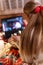 Behind female head with long blondie hair and red bow rear view watching the christmas movie on laptop at camping home in cozy bed