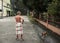 Behind of old man with loincloth standing with his pet on public street