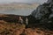 Behind shot of three friends hiking with a lake and mountains in the background