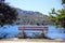 Behind the wooden bench, overlooking the blue waters of the lake and the tree-lined mountains, Alfedena, Abruzzo, Italy