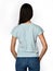 From behind. Young beautiful woman posing in gray light shirt blouse and blue jeans on a white