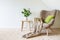 Beige armchair with a green pillow, blanket and a wooden table