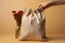 Beige background, a hand holds subsidy themed canvas bag, assistance concept