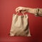 Beige background, a hand holds subsidy themed canvas bag, assistance concept