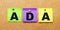 On a beige background, multi-colored stickers for notes with the word ADA Americans with Disabilities Act