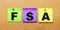 On a beige background, multi-colored stickers for notes with the word FSA Flexible Spending Account