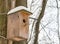 Beige birdhouse wooden box round entrance for birds on a tree trunk background with copy space