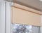 Beige blackout roller blind on the window