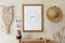 Beige boho interior of living room with mock up poster frame, elegant accessories, dried flowers in vase.