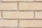 Beige brick outdoor wall of building background close-up.