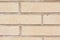 Beige brick outdoor wall of building background close-up.