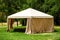 Beige canopy tent on green lawn garden