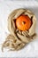 Beige classic soft scarf of fine pure cashmere with tassels and pumpkin on a white linen background