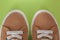 Beige corduroy sneakers on a green background