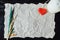 Beige crumpled paper with heart, candle and withered flower for