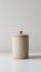 Beige cylindrical container with rounded lid on white background exudes minimalist charm