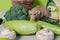 The beige decorative dumbo rat sits on vegetables. A cute mouse sniffs cauliflower and broccoli. Rodents love zucchini