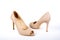 Beige elegant ladies` high-heeled shoes on a white background