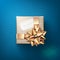 The beige gift box with the white greeting card and glittering golden bow with ribbons isolated on blue background