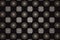 Beige gray interlaced pattern of squares and circles on a black background.