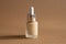 Beige make up foundation in luxurious glass bottle on brown background. Glamour make up still life with dark shadow. Feminine