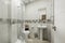 beige paneled bathroom with dark valance and frameless wall mirror