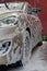 Beige passenger car in shampoo foam close-up left side vertical photography, car wash service