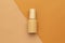 Beige plastic bottle of beauty skincare cosmetic mockup template on half beige and brown background.