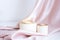 beige podium - top hat with gold top on pink satin background with folds.