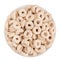 Beige rings corn flakes in white bowl isolated, top view. Cereals.