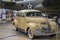 A beige royal windsor car next to an airplane at USS Alabama Battleship Memorial Park in Mobile Alabama