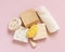 Beige soap bars, seashells, natural sponges and towel on light pink top view