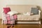 Beige sofa with plaid and colorful pillows pink, grey, white and tray with cups of coffee in the living room