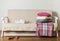 Beige sofa with plaid and colorful pillows pink, grey, white and tray with cups of coffee in the living room